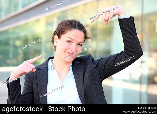 Front view portrait of a proud businesswoman pointing herself in the street