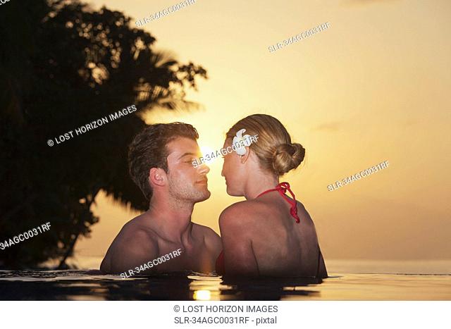 Couple embracing in infinity pool