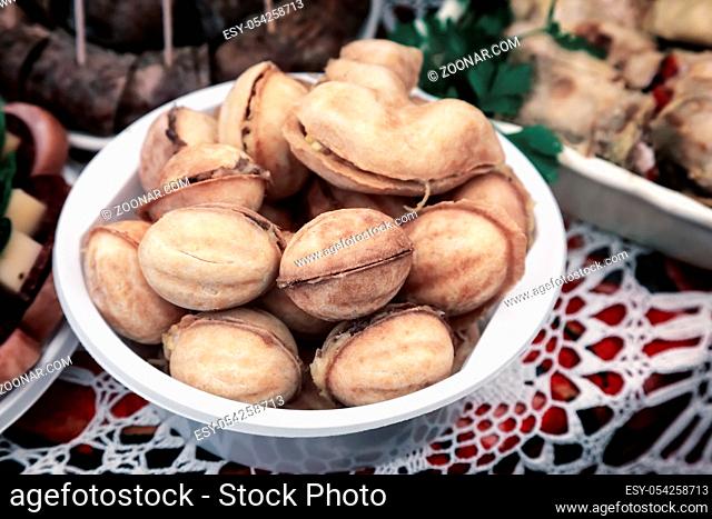 On the table on a lace napkin on a plate of delicious cookies in the shape of walnuts stuffed inside