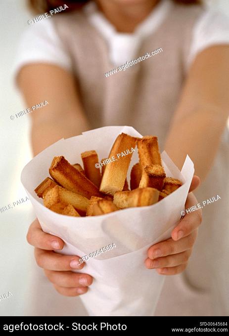 Girl holding bag of pieces of deep-fried cake
