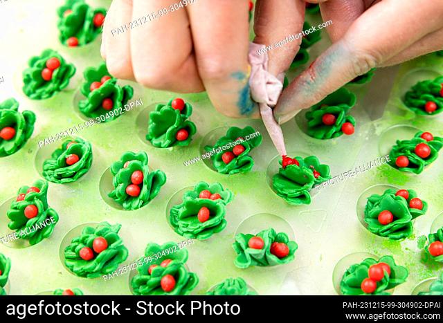 PRODUCTION - 13 December 2023, Thuringia, Erfurt: A pastry chef creates Christmas decorations for the baked specialties at the Lobenstein bakery and pastry shop