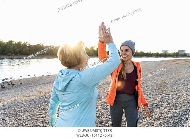 Grandmother and granddaughter high-fiving after training at the river