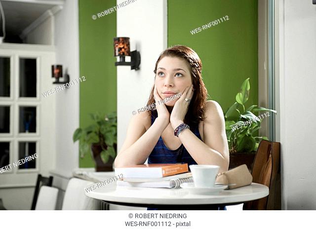 Germany, Bavaria, Munich, Young woman in cafe looking upset