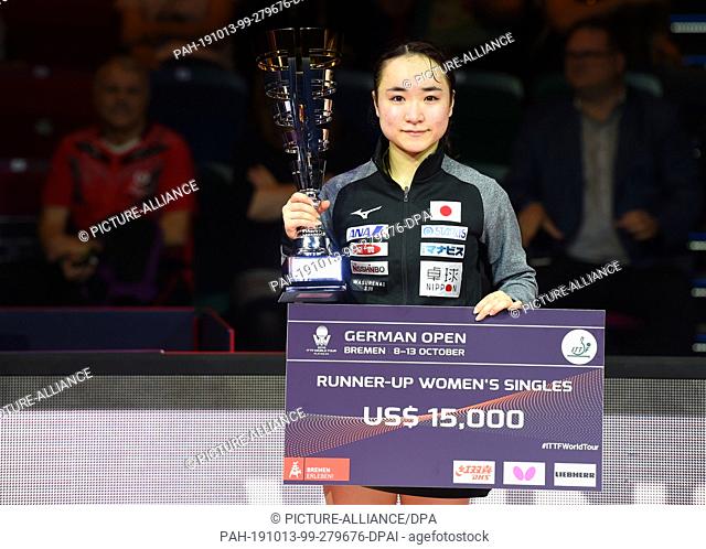 13 October 2019, Bremen: Table tennis: German Open, women's singles, final. Yingsha The second placed Mima Ito from Japan holds the trophy and check in her...