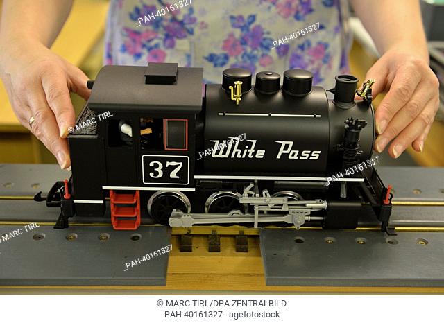 An employee presents a model locomotive of the type Spur-G at a storage facility of model railroad manufacturer Piko in Sonneberg, Germany, 11 June 2013