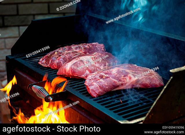 Pork meat steaks on the grill with flames