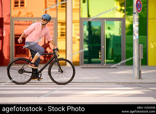middle-aged man on bicycle, urban, Munich, Germany
