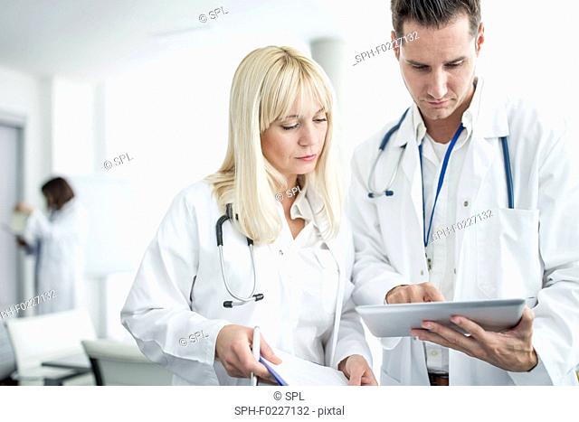 Male and Doctors inspecting digital tablet