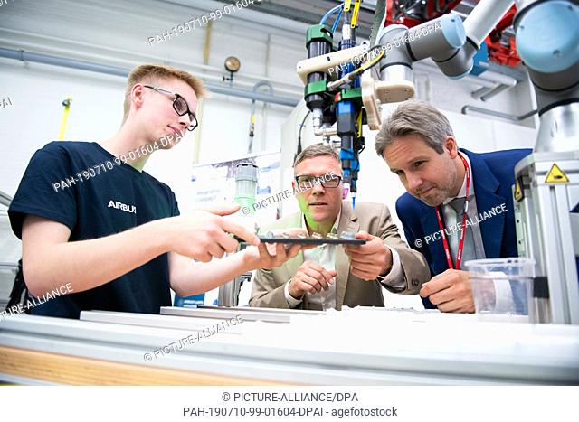 10 July 2019, Hamburg: Airbus trainee Daniel (l-r), Jan Balcke, head of the HR 4.0 project at Airbus, and André Mücke, Vice President of the Hamburg Chamber of...