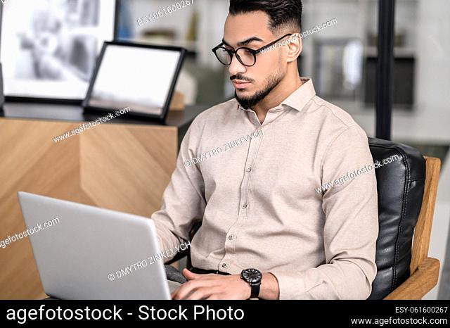 Working. A young good-looking businessman working on a laptop