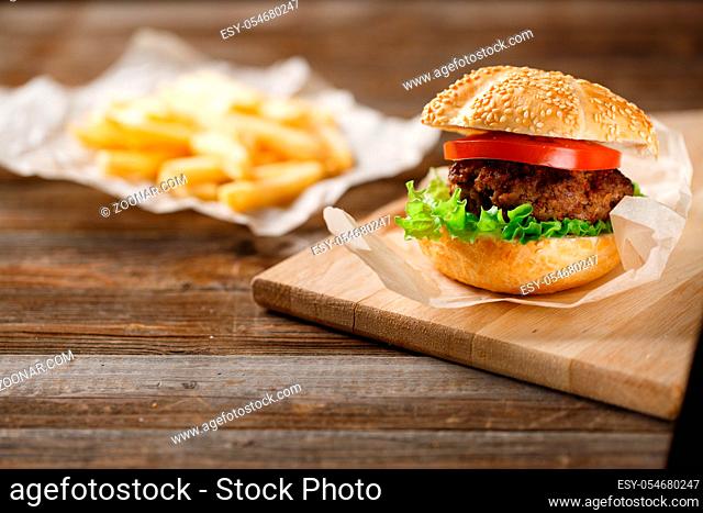 Homemade hamburgers and french fries on wooden table