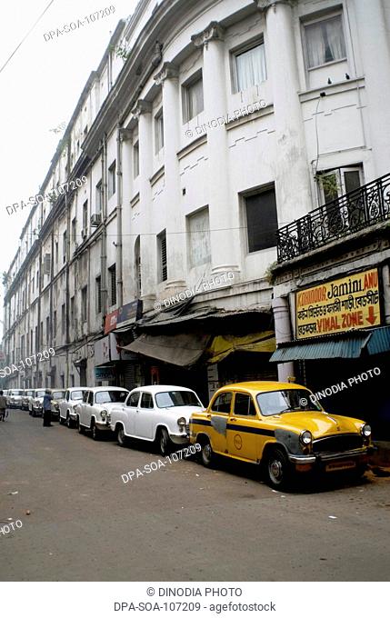 Taxis Standing in Row below the Building ; Kolkata ; West Bengal ; India