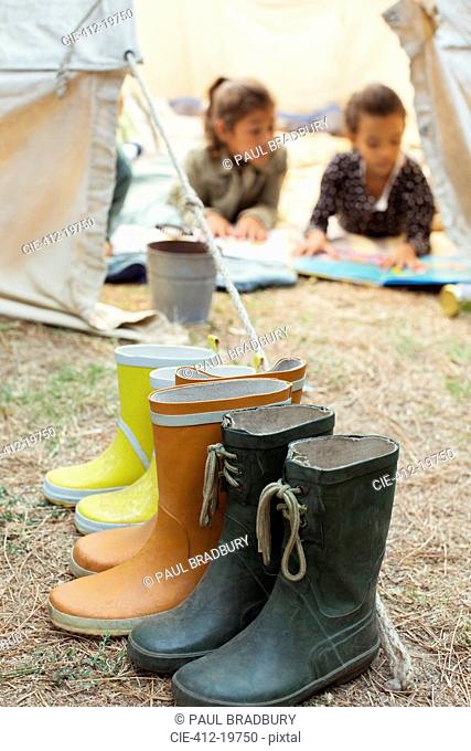 Rainboots lined up outside tent at campsite