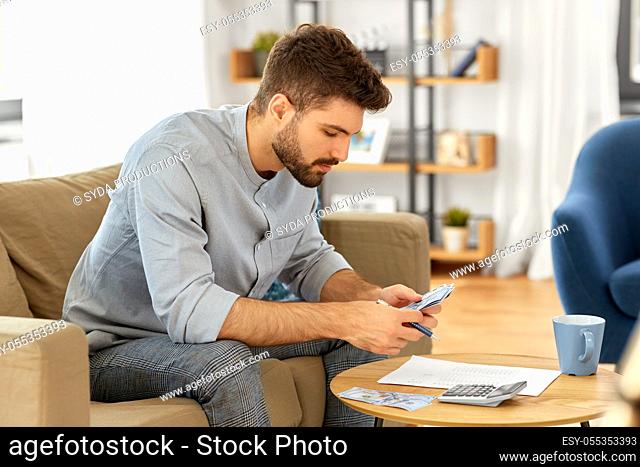 man with money and calculator filling papers