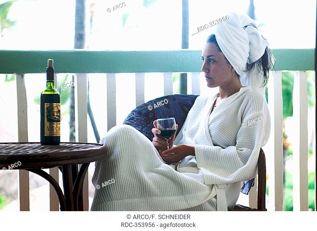 Young woman in bathing wrap, glass of wine, bath robe, towelling dressing gown