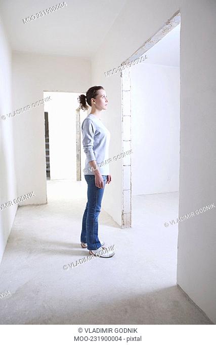 Woman stands in hallway of new apartment