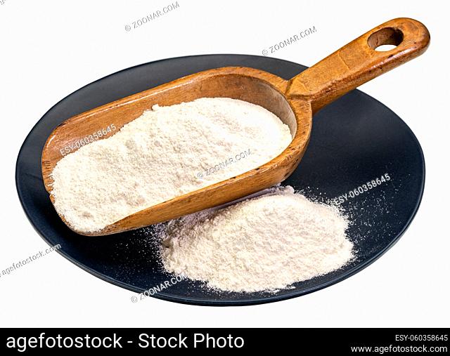 Cassava (yuca) flour on a wooden scoop and plate. It is a gluten free and grain free replacement for wheat flour