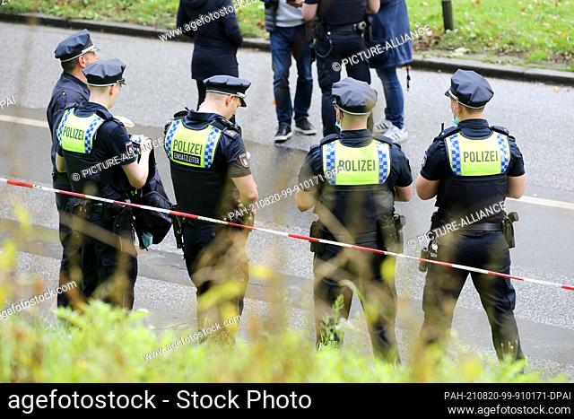 20 August 2021, Hamburg: Emergency forces stand at a police cordon on the Gorch-Fock-Wall. Witnesses heard shots in the center of Hamburg on Friday - a large...