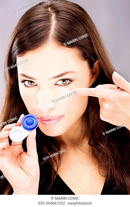 woman holding contact lenses