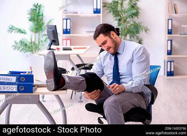 Young leg injured employee working in office