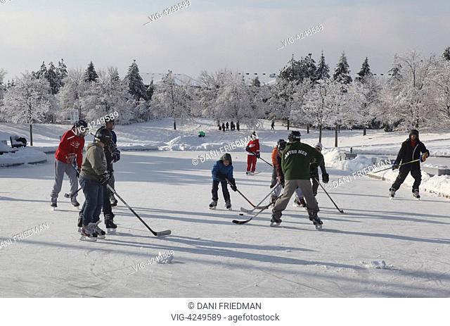 Children play a game of ice hockey on an outdoor ice rink in Ontario, Canada. Hockey is a national pastime for many Canadians who consider Canada as a Hockey...