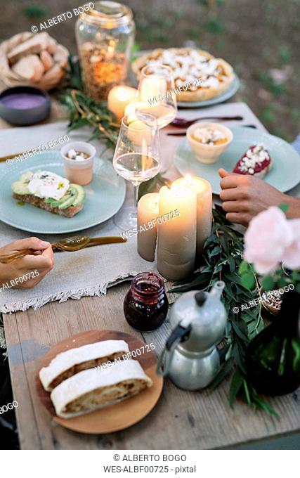 Close-up of couple having a romantic candlelight meal outdoors