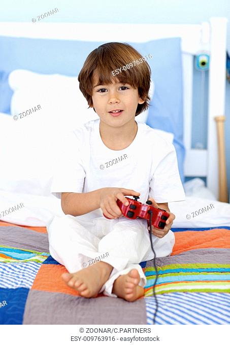 Boy sitting in bed playing videogames