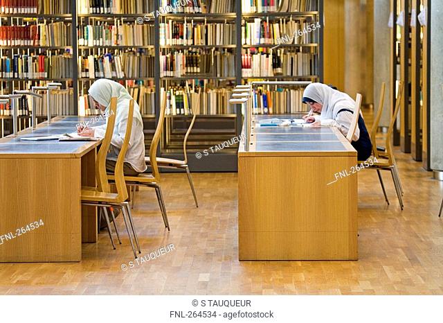 Two women sitting in library