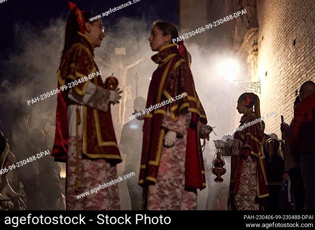 05 April 2023, Spain, Granada: Acolytes stand before the Cristo del Consuelo (Christ of Consolation) in a pause for the bearers