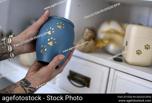 PRODUCTION - 03 October 2022, Brandenburg, Heideblick: Stephanie Badura holds an urn with the ashes of one of her deceased foster dogs
