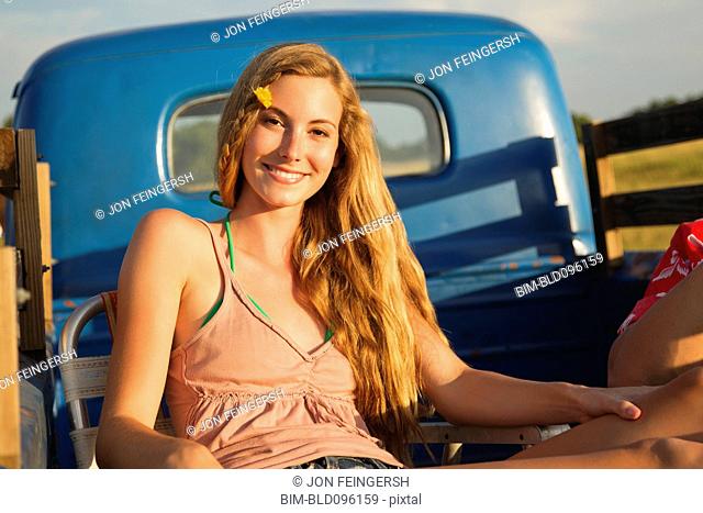 Caucasian woman sitting in back of truck