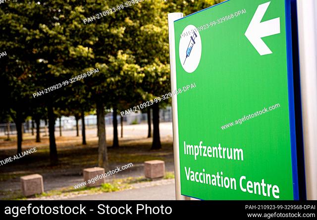 23 September 2021, Lower Saxony, Hanover: The words ""Impfzentrum - Vaccination Centre"" can be read on a signpost in front of the vaccination centre on the...