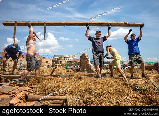 People clean debris and repair houses after a tornado storm which passed through the Hrusky village in the Breclav district, South Moravia, Czech Republic