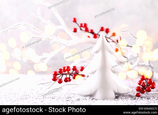 Christmas or new year greeting card white tree branch with red holly berries ceramic ornament on snow copy space