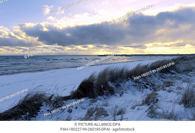 27 February 2018, Germany, Scharbeutz: Clouds move aboce the snow-covered Baltic Sea beach. Photo: Carsten Rehder/dpa. - Luebeck/Schleswig-Holstein/Germany