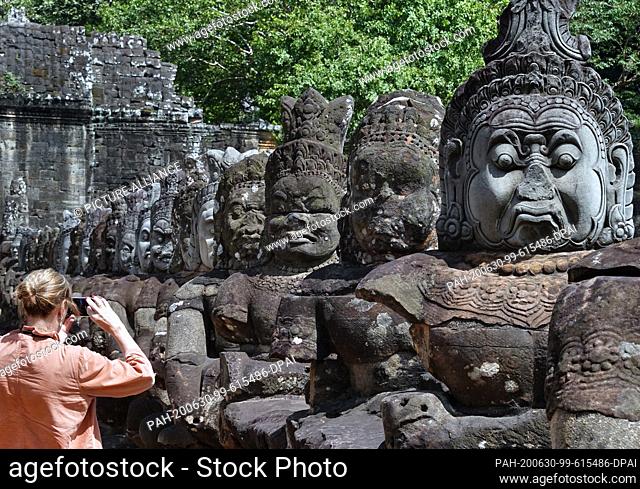 23 October 2019, Cambodia, Siem Reab: Demons as stone figures on a bridge to the south gate of the capital Angkor Thom in the temple complex