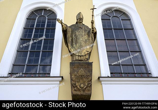 13 January 2022, Bavaria, Altötting: A figure of Pope Emeritus Benedict XVI hangs on a facade on Kapellenplatz in the center of the village