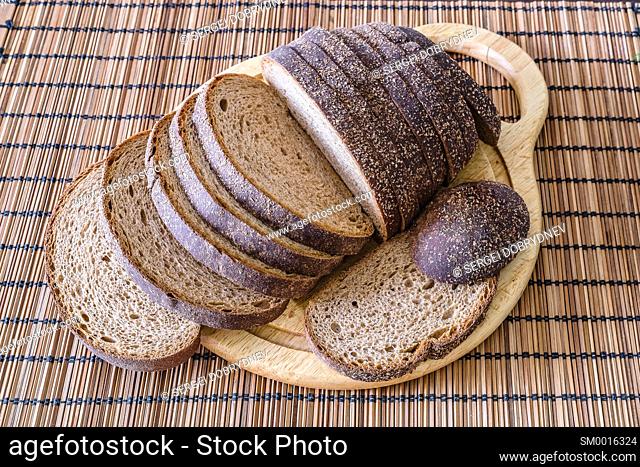 Sliced loaf of rye bread on a cutting board close up