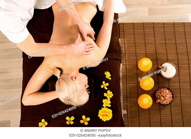 Young Woman Receiving Back Massage From A Massager In A Beauty Spa. High Angle View
