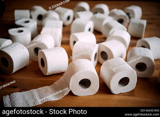Stack of white tissue toilet paper rolls lying on the floor next to each other