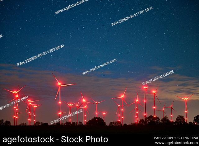 PRODUCTION - 06 May 2022, Brandenburg, Jacobsdorf: The red position lights on wind turbines illuminate the night sky and the landscape