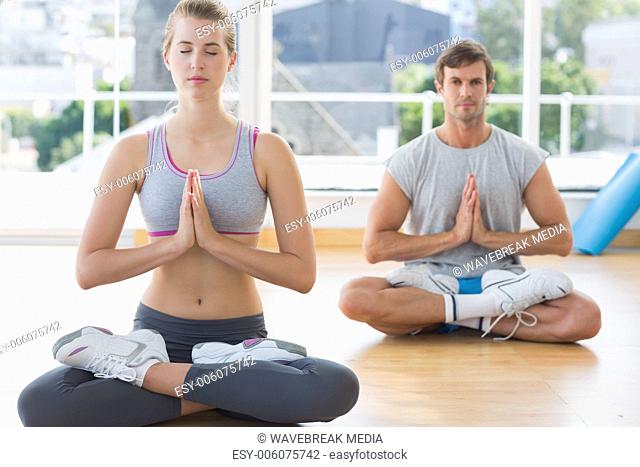Couple in meditation pose at fitness studio