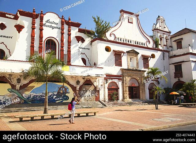 Local people walking in front of the colonial buildings used as Teatro Cartagena and Teatro Colon at the historic center, Cartagena de Indias, Bolivar, Colombia