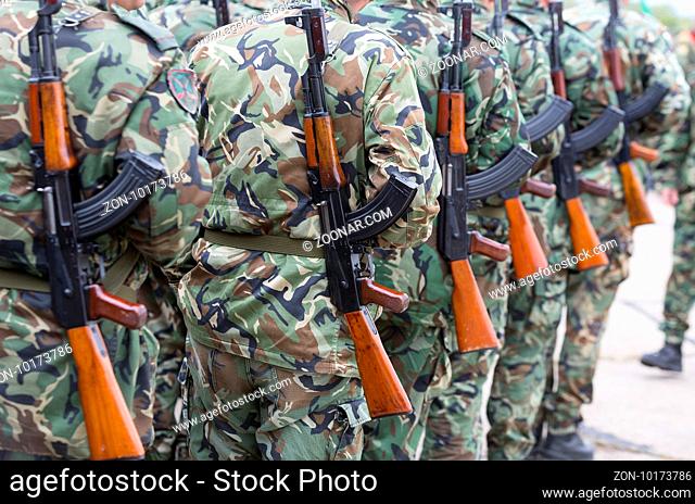 Soldiers from the Bulgarian army are preparing for a parade for Army's day in uniforms with Kalashnikov AK 47 rifles. Seen from thei backs