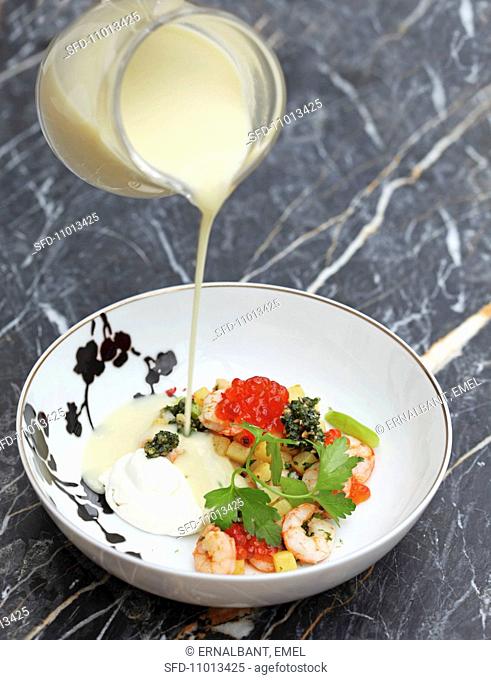 Potato soup with prawns, pesto and salmon caviar