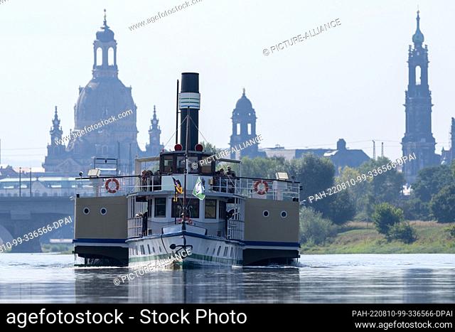 10 August 2022, Saxony, Dresden: The historic paddle steamer ""Meissen"" sails on the Elbe against the backdrop of Dresden's Old Town