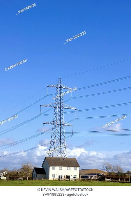 Electricity tower and detached house in rural area