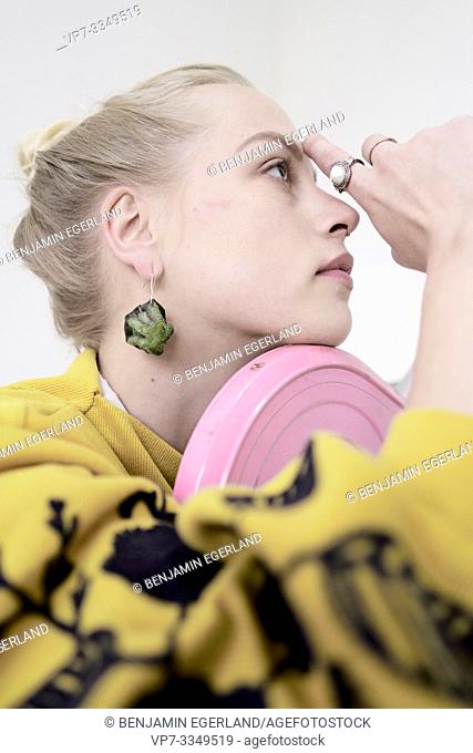 young woman wearing earring made of raw zucchini