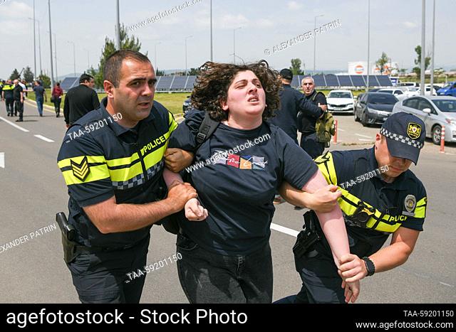 GEORGIA, TBILISI - MAY 19, 2023: Police officers detain a woman during a demonstration at Shota Rustaveli Tbilisi International Airport where an Azimuth flight...