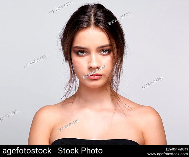 Beauty portrait of young woman. Female on gray background